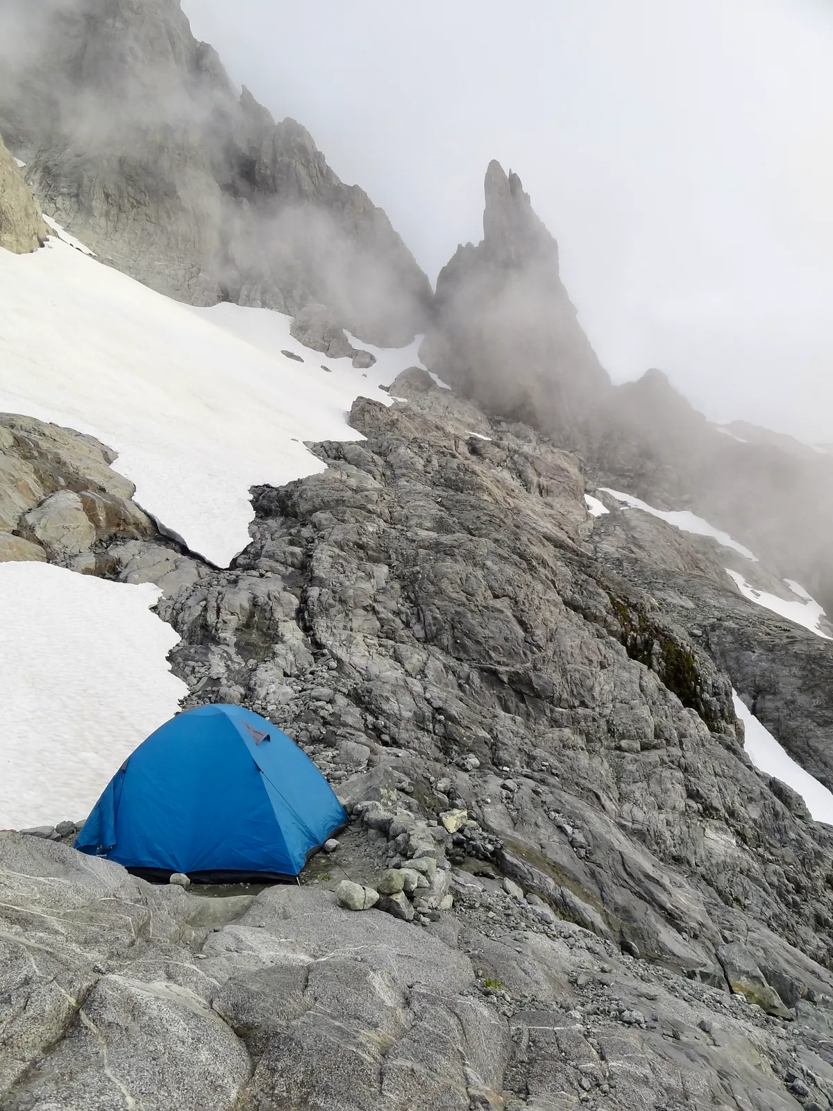 Our blue tent on a rocky ledge at the bivouac before the Mount Tutoko summit attempt.