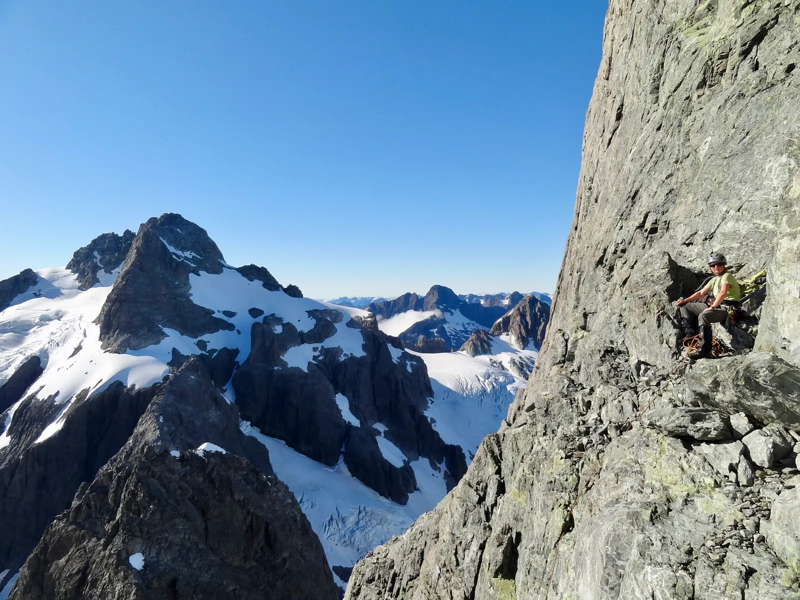 Resting on a ledge after climbing a rock pitch on Mount Tutoko.