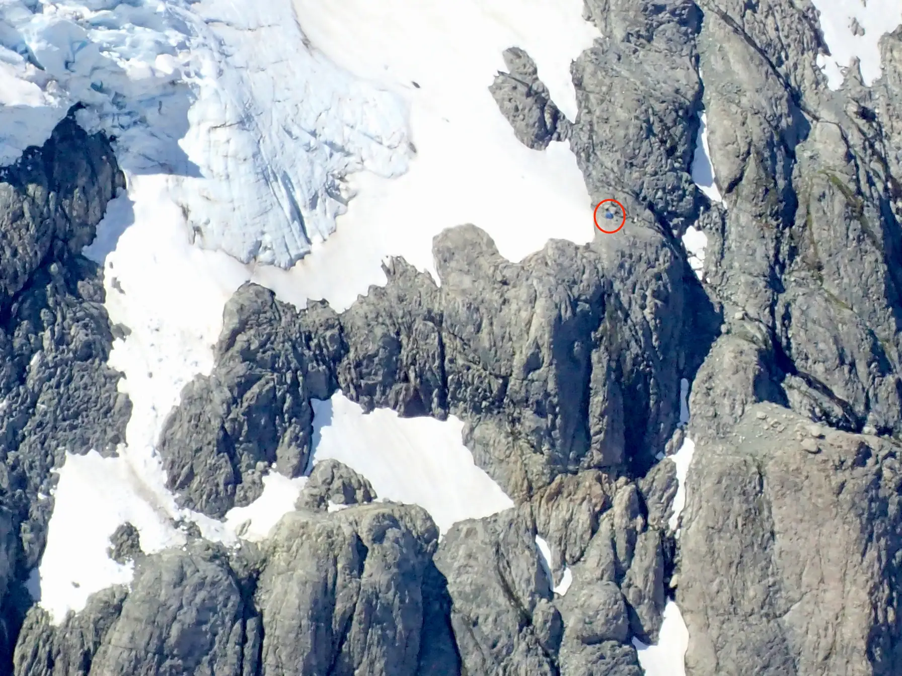Close-up of the opposite rock face, with our tent visible as a tiny blue dot marked with a red circle.